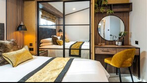 A modern hotel room with a bed, a desk, a chair, a mirror, and a plant. - Sure Studio by Best Western Brackenborough Lakes & Resort (Louth)