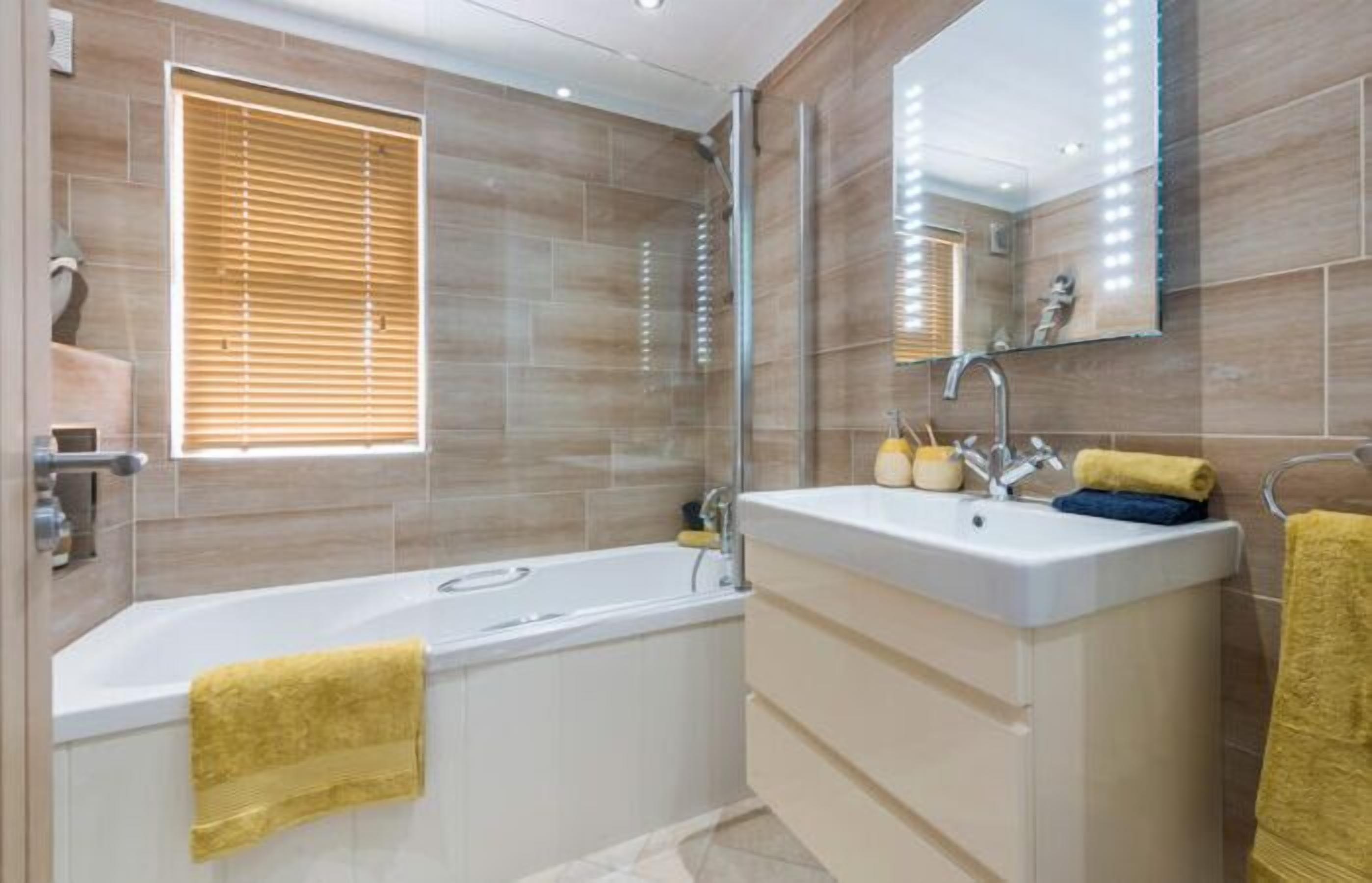 Une salle de bain moderne avec une baignoire, un meuble-lavabo et un miroir.