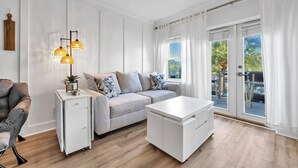 A modern living room with a sofa, a coffee table, a side table, and a lamp.