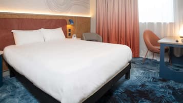 Une chambre d’hôtel avec un grand lit, un bureau, une chaise et une vue sur l’extérieur.