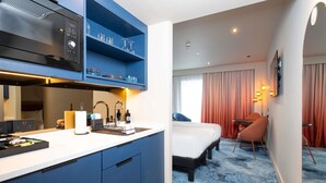 A hotel room with a kitchenette, a bed, a dining area, and a bathroom. - ibis Styles Burton Upon Trent - Hotel & Suites (Burton on Trent)