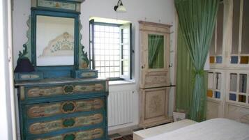 Un dormitorio con cama, cómoda, espejo, ventana con vistas y armario.