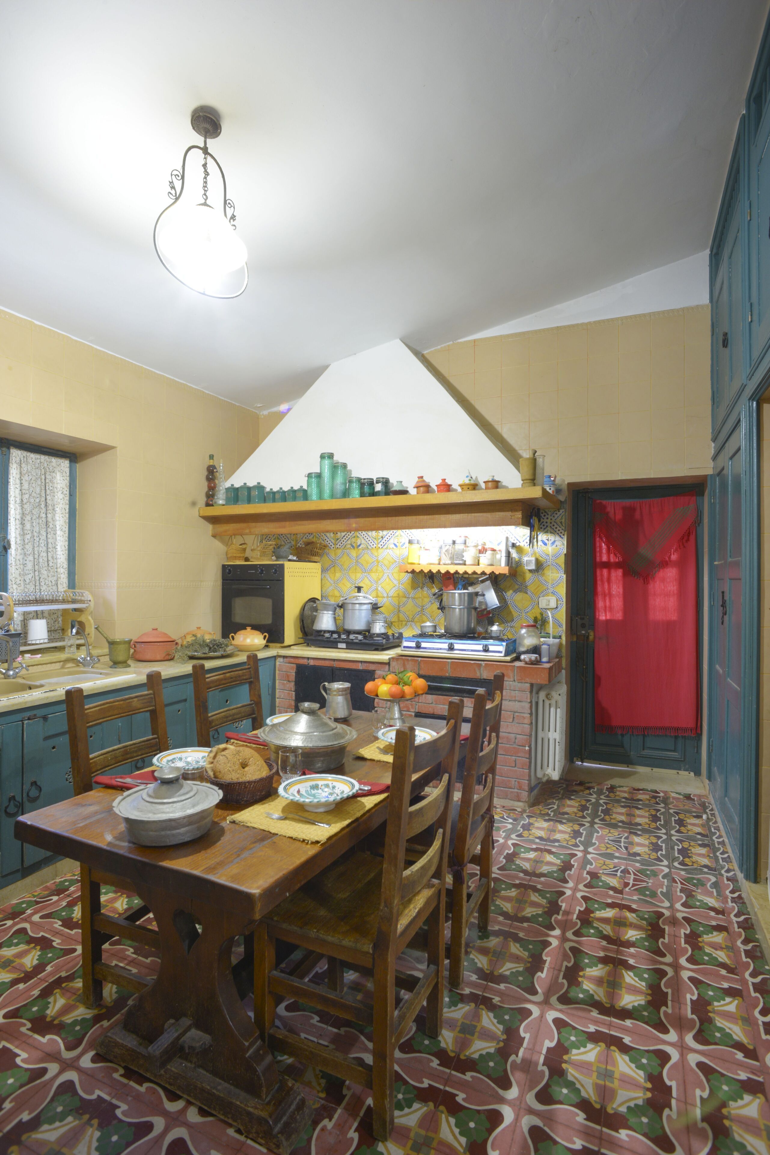 A traditional kitchen with a dining table, chairs, and various kitchen appliances.
