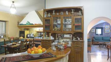 A kitchen with a central island, wooden cabinets, and a dining area with chairs.