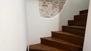 Un escalier avec des marches en bois et un mur en pierre.