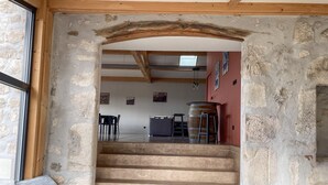 A staircase leading to a dining area with stone walls and wooden beams. - Gîte des Ollières : Entre Charme Traditionnel et Confort Moderne (Monistrol-sur-Loire)