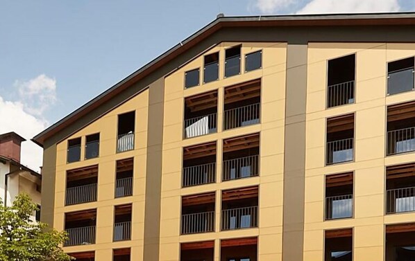 Un immeuble à plusieurs étages, doté d’une façade beige et de nombreux balcons.