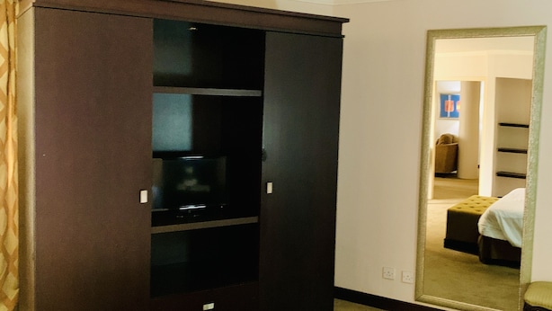 Una habitación de hotel con un armario grande, una cama y un espejo que refleja un armario y una cama.