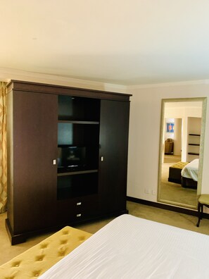 Una habitación de hotel con un armario grande, una cama y un espejo que refleja un armario y una cama.