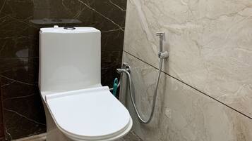 Een douche, handdoeken, zeep, toiletpapier