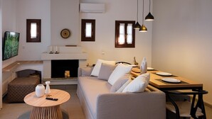 Een moderne woonkamer met een bank, een eettafel en een open haard.