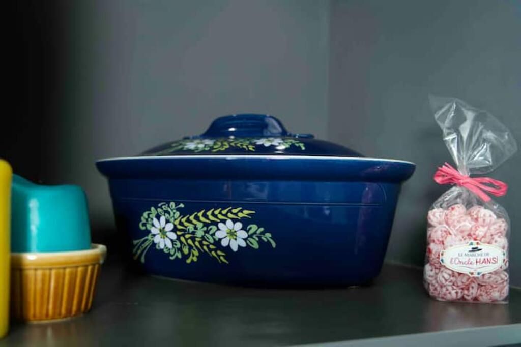 A blue container with floral designs and a plastic bag of pink candies.