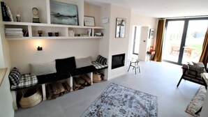 A spacious living room with a fireplace, a large window, and a view of the outdoors. - "maison56"- Maison Cosy, Piscine, Entre Blois-chambord, 4 Chb, Proche Loire (Montlivault)