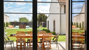 A modern interior with large glass doors leading to an outdoor patio area. - "maison56"- Maison Cosy, Piscine, Entre Blois-chambord, 4 Chb, Proche Loire (Montlivault)