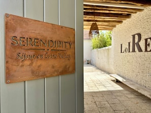 Un letrero con el texto 'SERENDIPITY' y 'Séjour en Loire Valley', techo de madera y una pared con el texto 'Loire'.