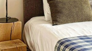 A neatly made bed with white bedding and a striped throw, a wooden nightstand with a lamp, and a textured headboard. - "maison56"- Maison Cosy, Piscine, Entre Blois-chambord, 4 Chb, Proche Loire (Montlivault)