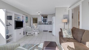A compact living space with a kitchenette, a dining area, a sofa, and a TV. - Beach & Tennis 1501 (Bonita Springs)