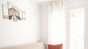 Une chambre moderne avec un canapé-lit, une table de chevet et une œuvre d’art accrochée au mur.