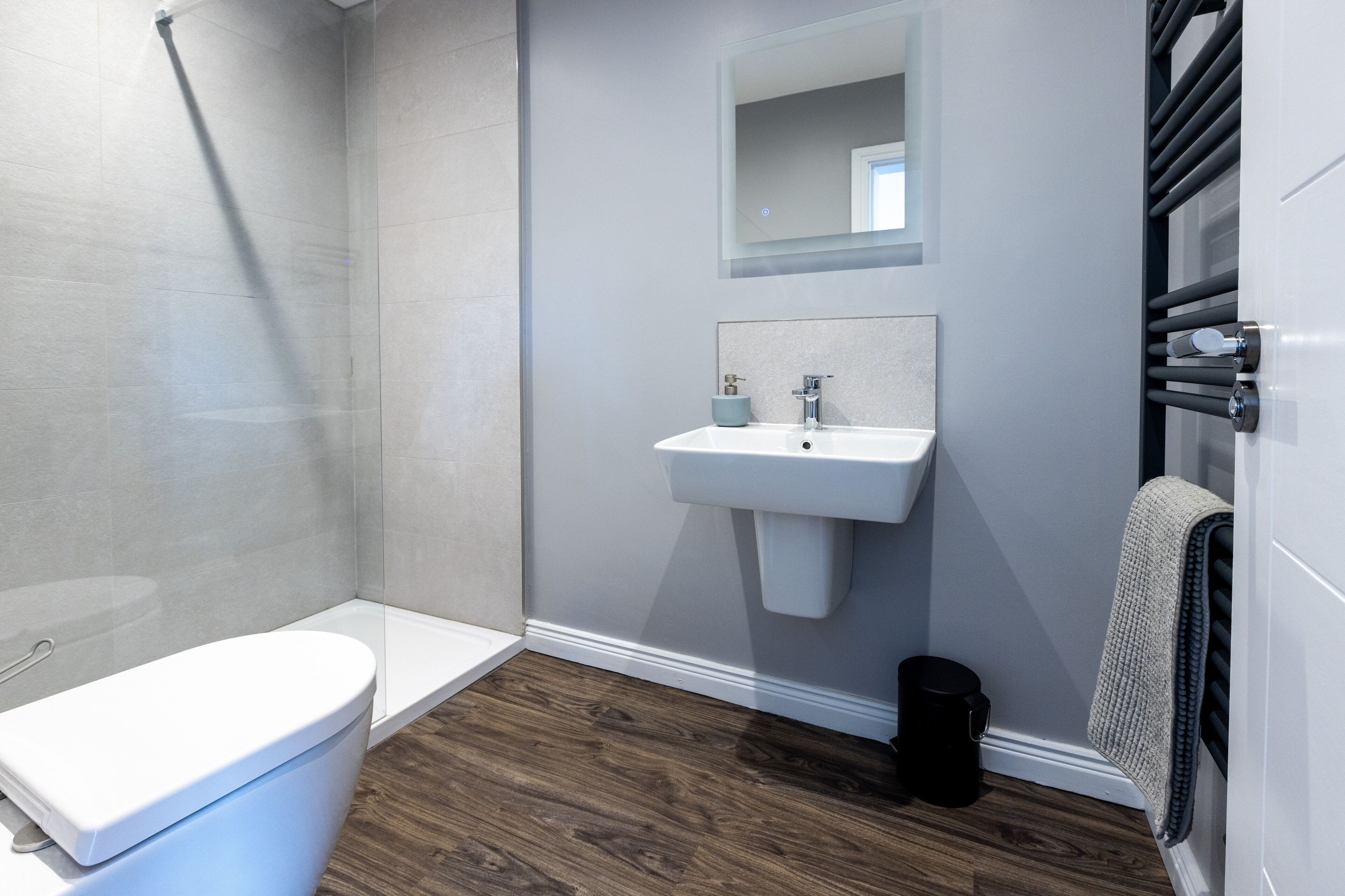 Un baño moderno con inodoro, lavamanos y ducha.
