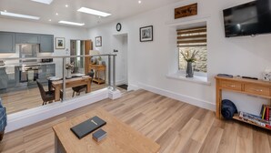 A modern living space with a kitchen, dining area, and a large TV. - 1 bedroom accommodation in Consett, County Durham (Consett, County Durham)