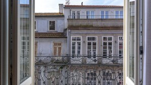 A view from a balcony with a wrought iron railing, overlooking a courtyard with a building in the background. - Limehome Porto Rua 31 de Janeiro (Porto)