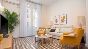 Un salon moderne avec un canapé, des fauteuils, une table basse et un sol à motifs.