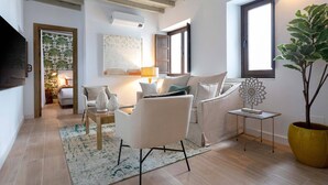 Una sala de estar moderna con un sofá, sillones, una mesita de centro y una planta en maceta.