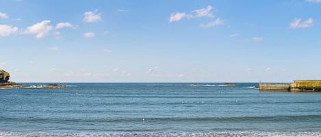 Une plage avec un ciel dégagé et une mer calme.