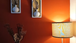 Um quarto com uma mesa de madeira, um abajur e dois objetos decorativos fixados na parede.