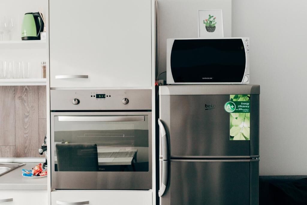 Cuina amb forn d'acer inoxidable, nevera i microones.