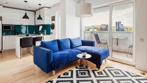 A modern living space with a blue sofa, a small round table, and a patterned rug. - DD Apartments (Cluj-Napoca)