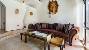 A living room with a brown leather sofa, a wooden coffee table, and a fireplace. - Beautiful  villa for 8 people with WIFI, TV, terrace and pets allowed (Marcali)