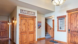 Un intérieur en bois avec une enseigne indiquant « STYLE DE VIE AU BORD DU LAC » et un escalier menant à un autre niveau.