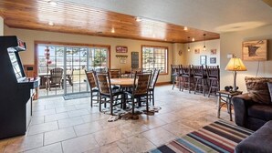Un espace intérieur spacieux comprenant une table et des chaises, une cheminée et une grande fenêtre donnant sur une terrasse.