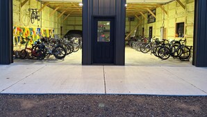 A building with two large open doors, a row of bicycles inside, and a sign that reads 'Bike Motor Lodge'. - Boulder Bear Motor Lodge - Two Queen Beds 103 Front (Boulder Junction)