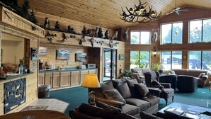 A cozy lodge interior with a dining area, kitchen, and seating space. - Boulder Bear Motor Lodge - Two Queen Beds 103 Front (Boulder Junction)