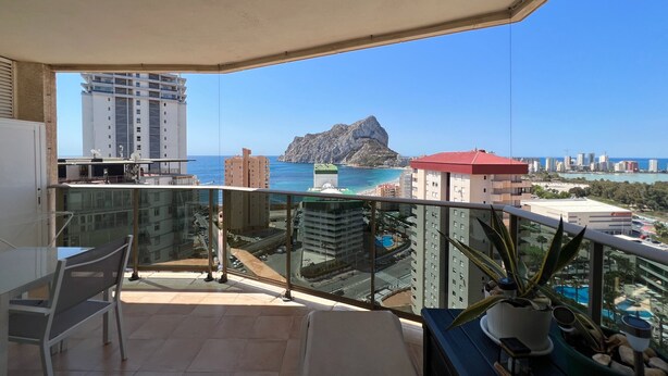 Un balcón con vista al mar y edificios.