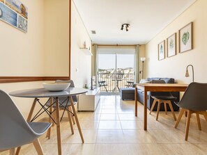 Relax in a stylish living area with a dining table, sofa, and coffee table, plus a balcony with a view.