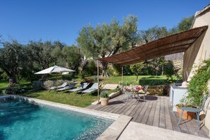 Relax by the pool surrounded by lush greenery and a tranquil atmosphere.