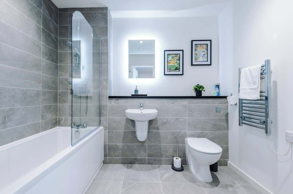 Ein modernes Badezimmer mit Badewanne, Toilette und Waschbecken.