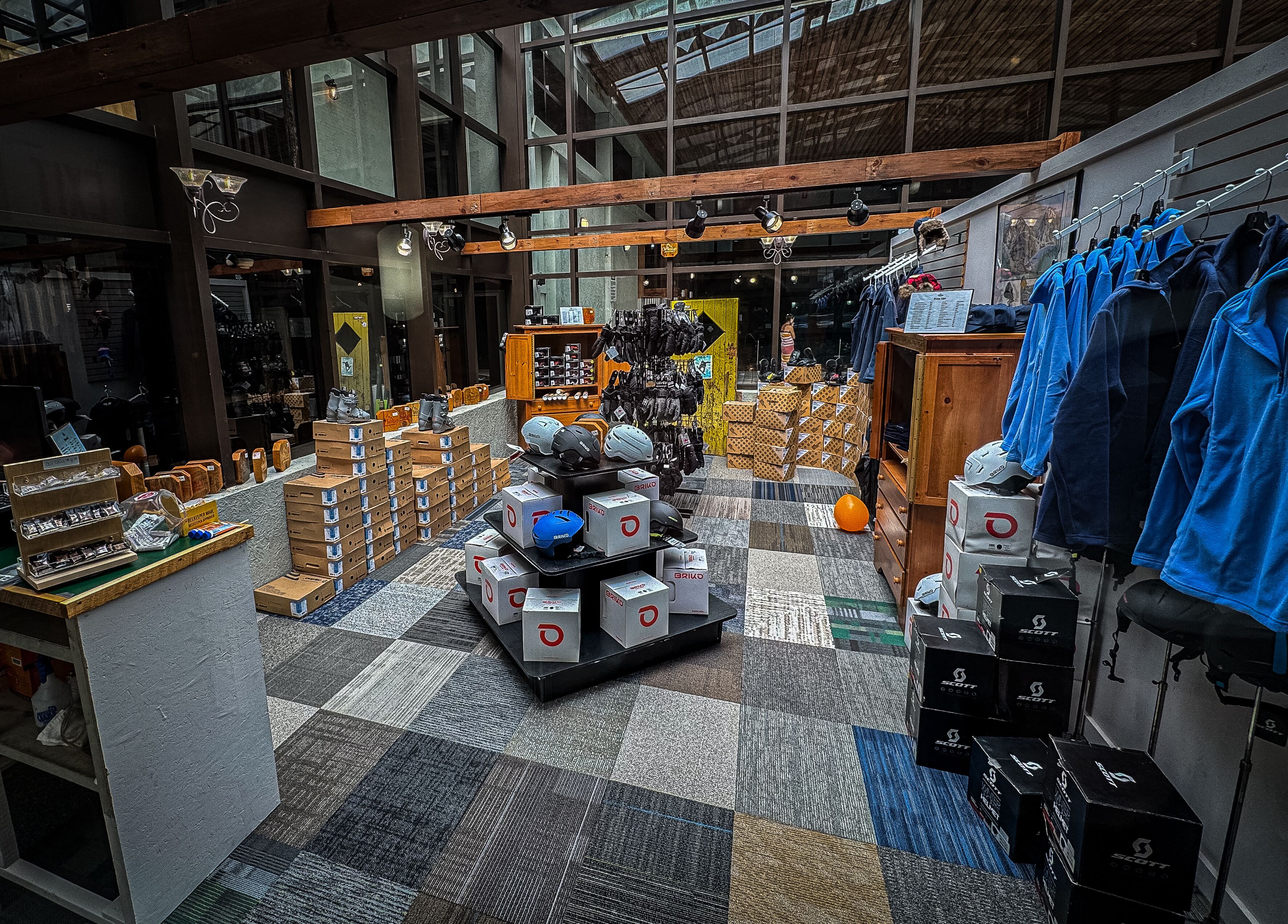 A spacious retail store with a variety of products on display, including shoes, helmets, and clothing.