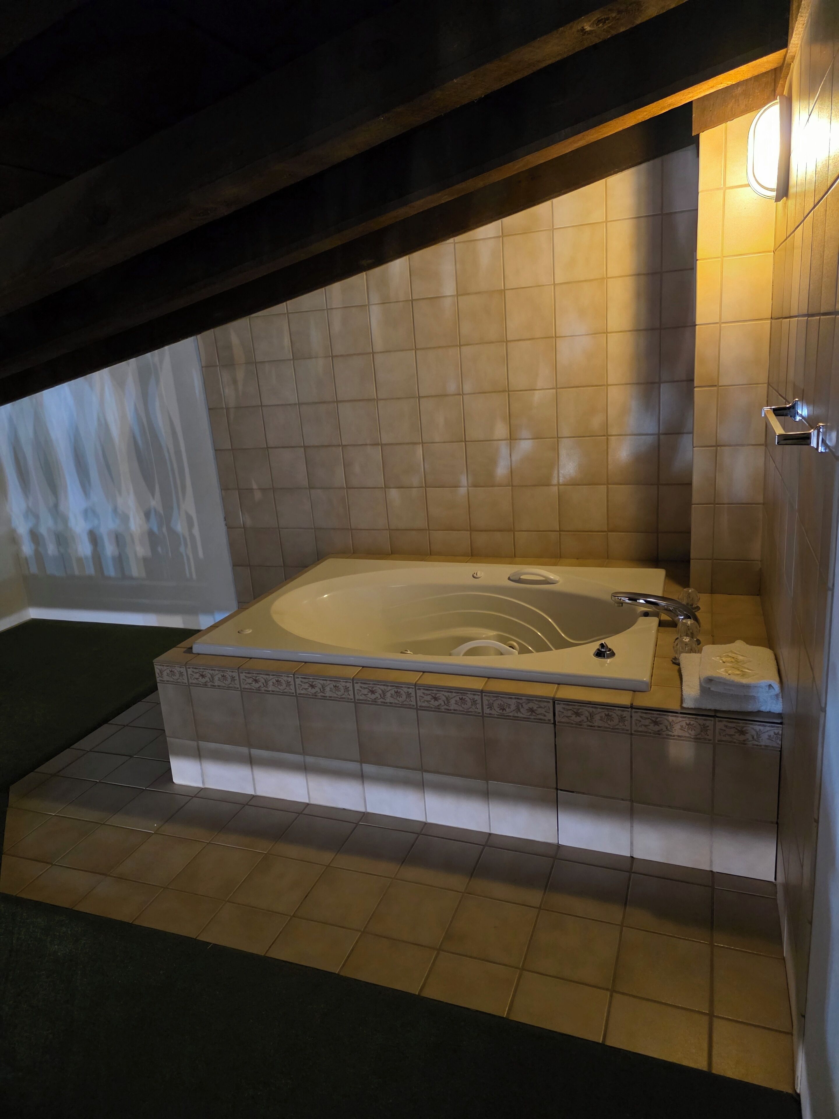 Un baño con una bañera grande, un lavamanos y un perchero para toallas.
