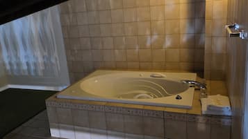 Un baño con una bañera grande, un lavamanos y un perchero para toallas.