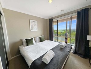 Une chambre d’hôtel avec un grand lit, une vue sur l’extérieur et un balcon.