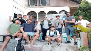 A group of people gathered outside a building with a white facade and arched windows. - Second Hope Lodge (Padang)