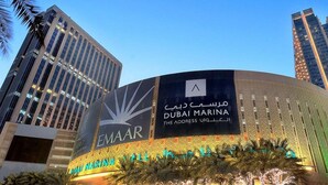 Ein modernes Gebäude mit einem großen Schild für 'Dubai Marina' und 'EMAAR'.