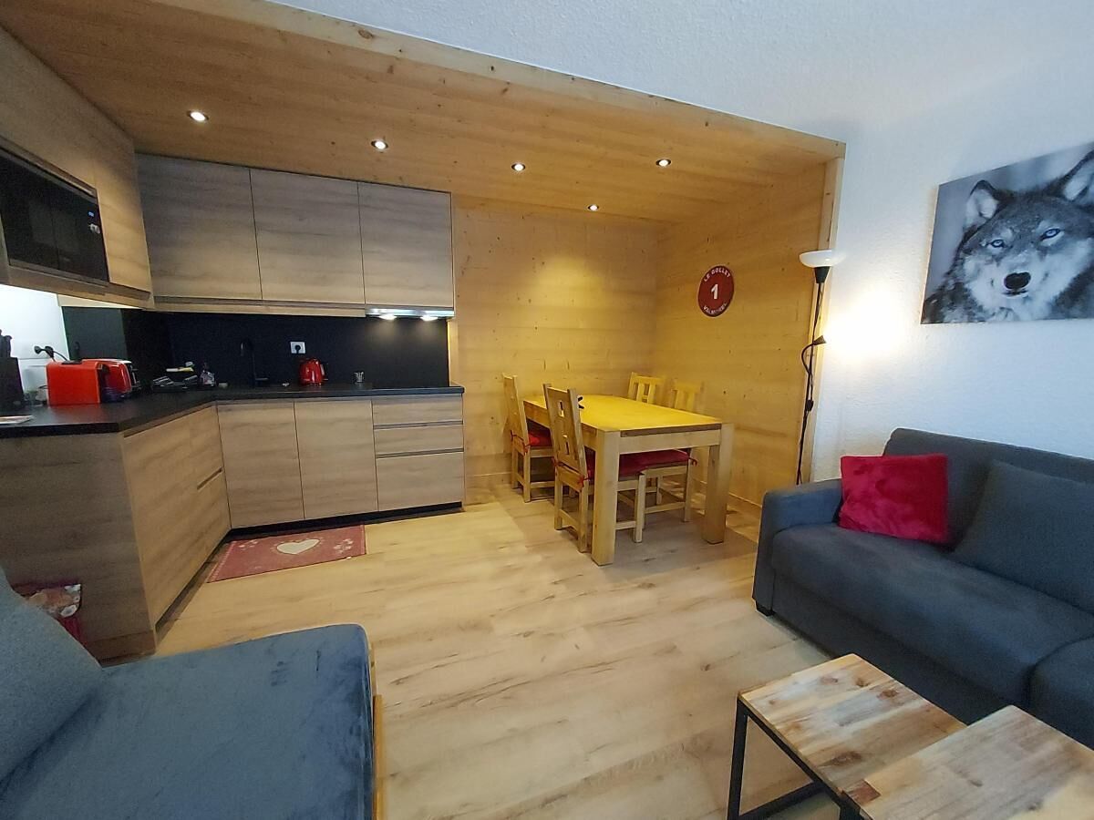 A modern living space with a kitchen, dining area, and seating.