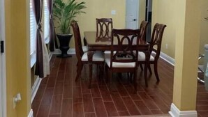 Comedor con candelabro, mesa de madera y sillas.