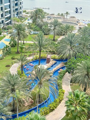 Ein Resort mit großzügigem Poolbereich, umgeben von Palmen, einer Anlegestelle und Blick auf das Meer.
