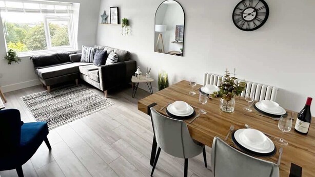 Un salon moderne comprenant un coin repas, un canapé, une table basse et une table à manger pour deux personnes.